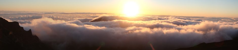 The sun rises from the clouds over Maui, taken from the peak of Haleakala